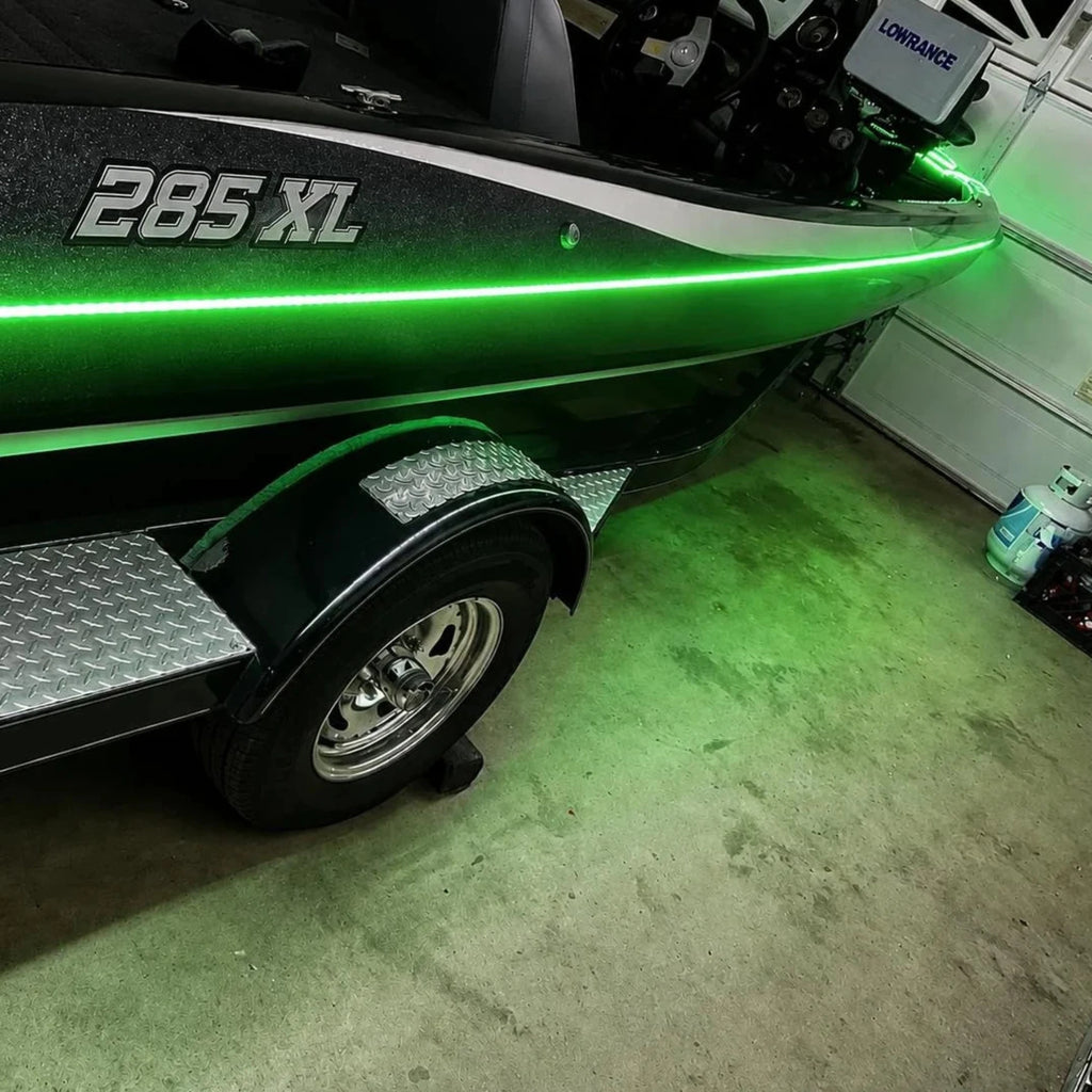 Green boat with '285 XL' on a trailer in a garage.